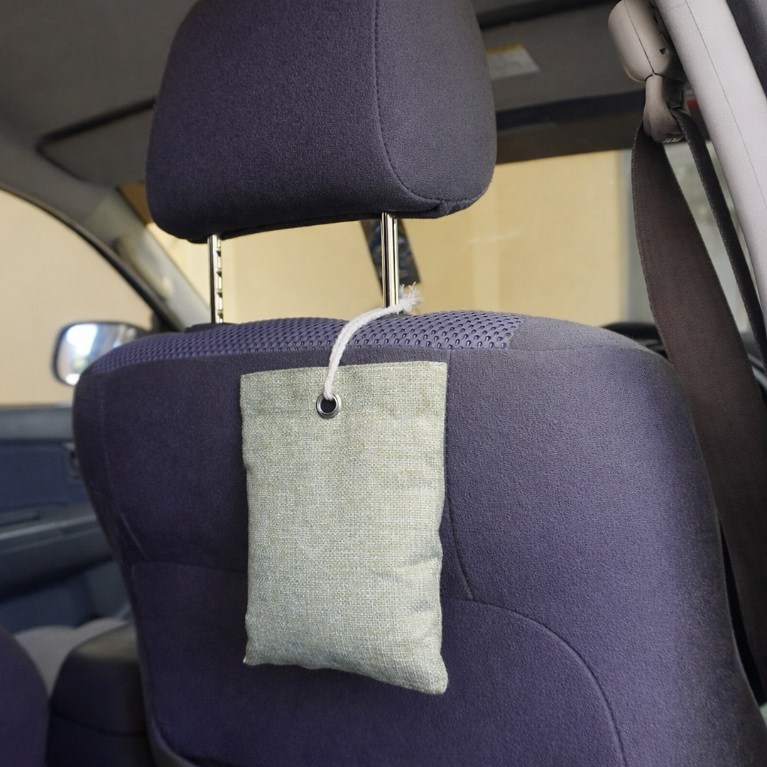 Green moisture and odour absorber hanging from a car headrest